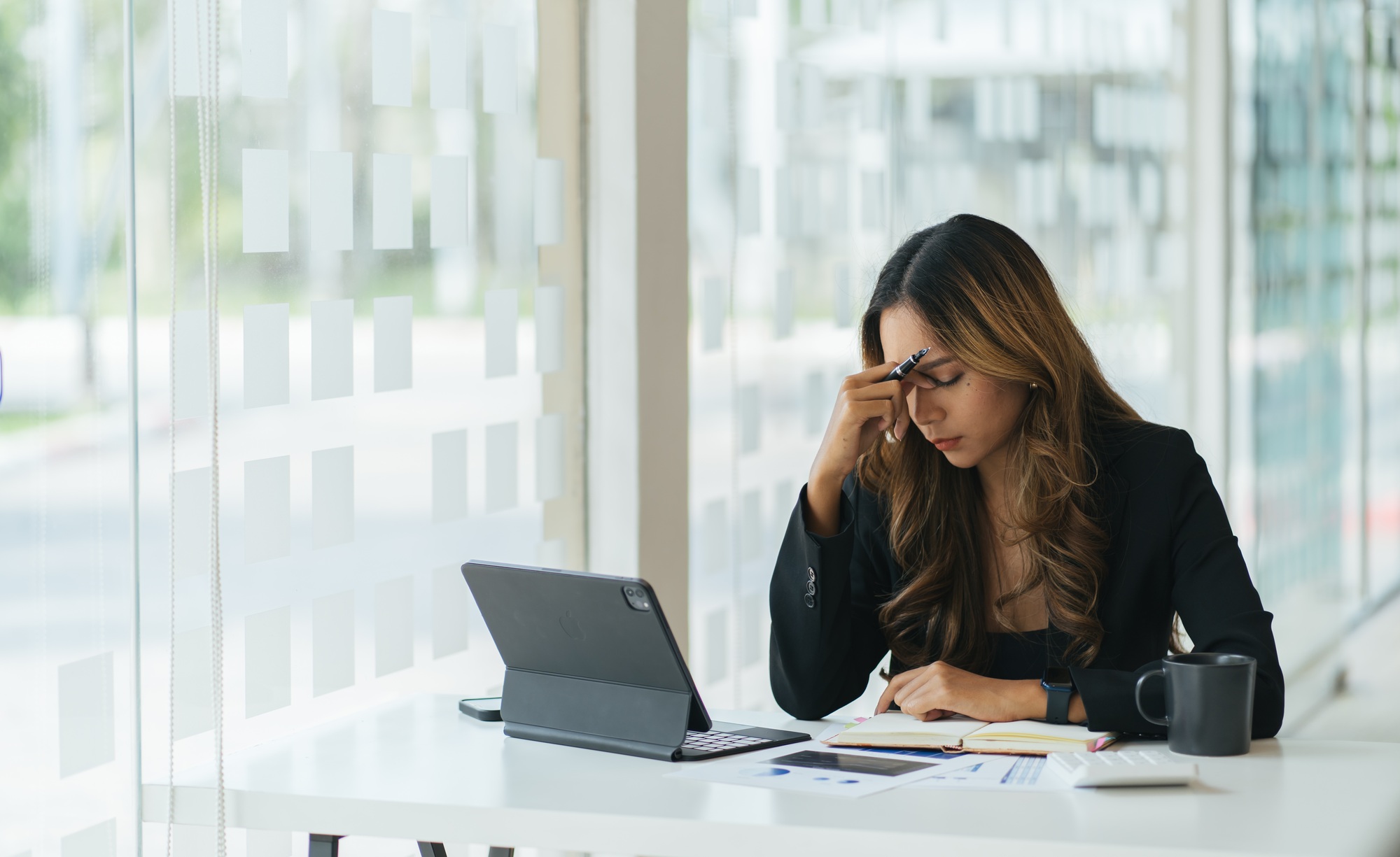 Young asian women are bored at work and feel lazy to deal with data on their laptop in the afternoo